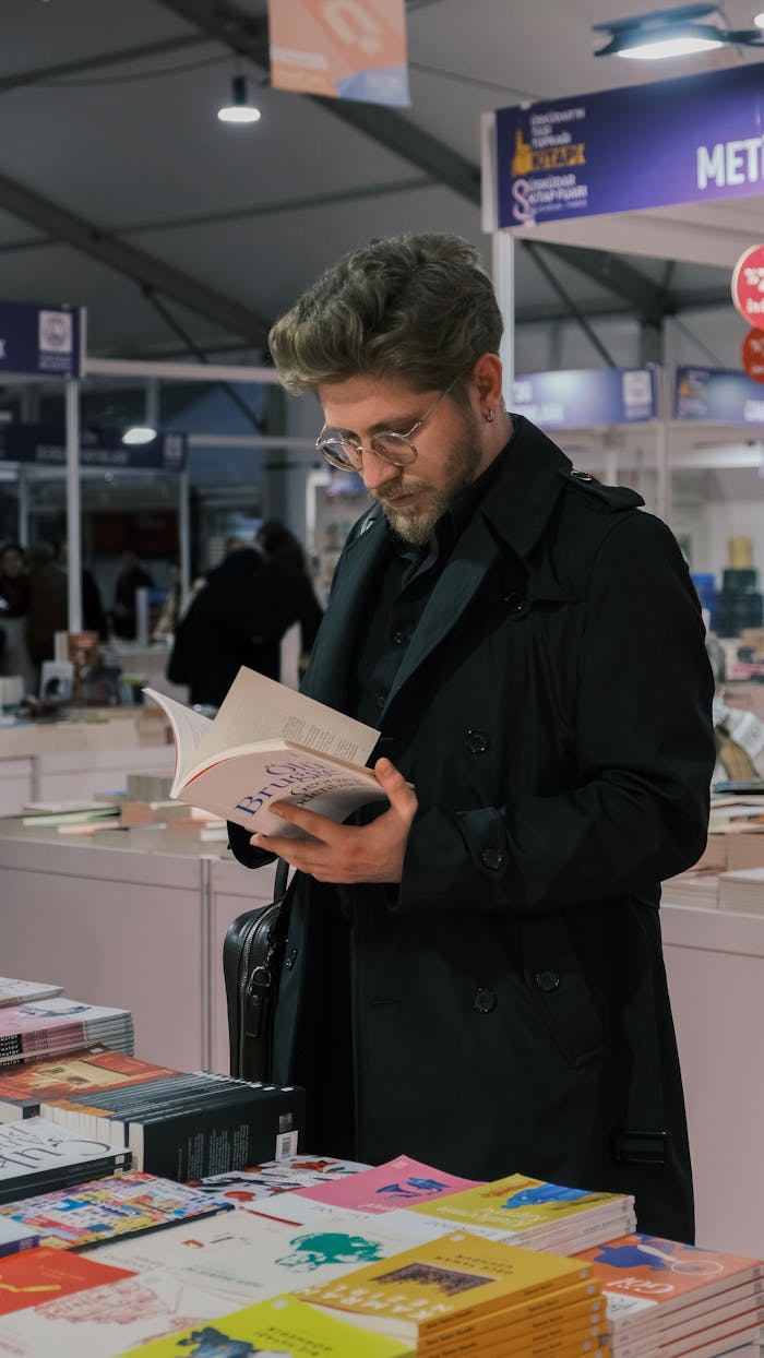 Adult male browsing and reading books at an indoor bookstore event