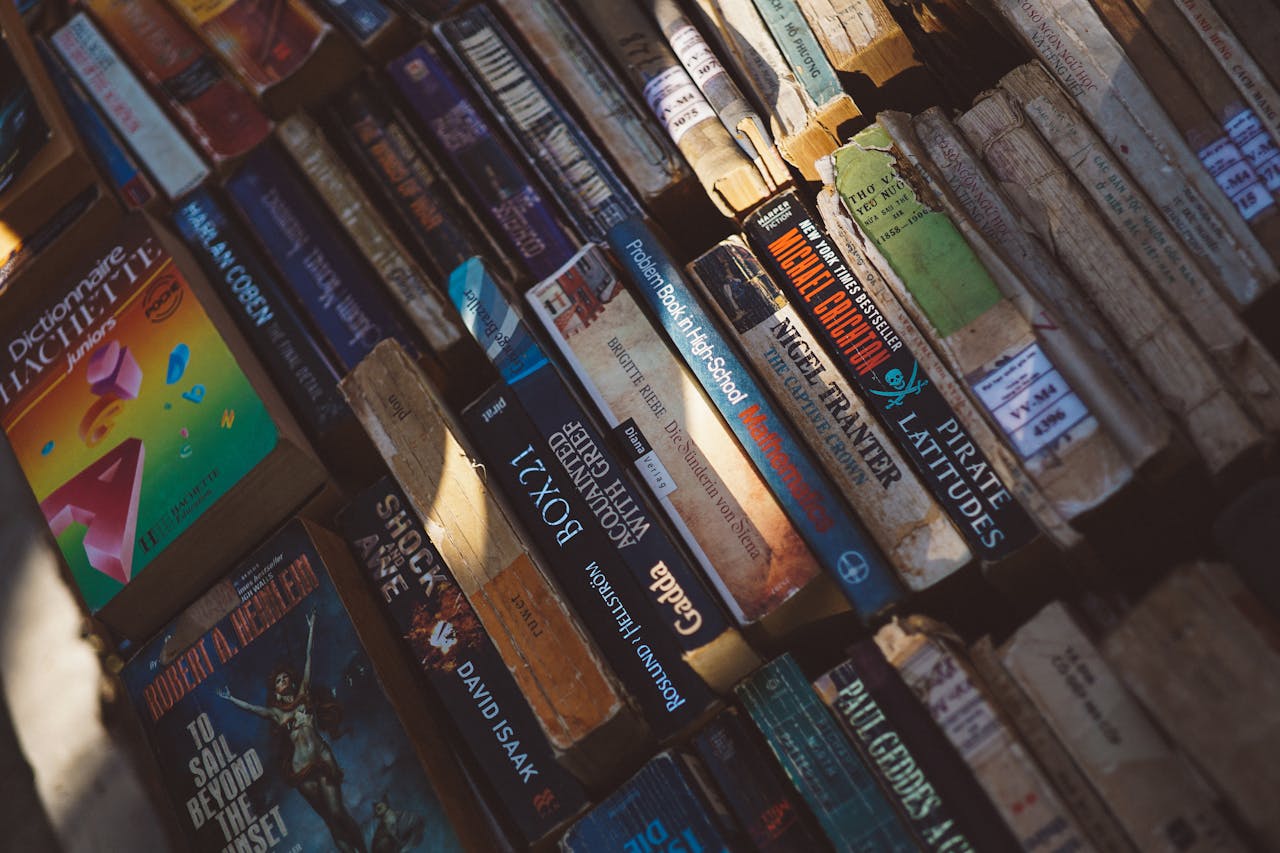Photo of diverse vintage books stacked outdoors, capturing the essence of a book market.
